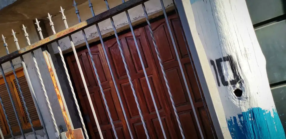 Iron gate and painted post with a hand-painted 10, in the Rosario neighbourhood where Messi grew up.