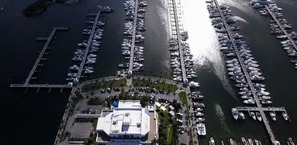 Top-down aerial view of a marina (the stock page tags it Miami): rows of moored boats and sun on the water.