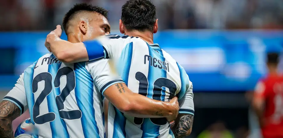 Lautaro Martinez with his arm around Messi, both seen from behind in Argentina stripes. Argentina v Egypt, 7 July 2026.